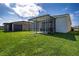 Expansive backyard with green grass and a covered patio area at 153 Summershore Dr, Auburndale, FL 33823