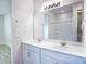 Bright bathroom features double vanity, white cabinets, and white-tiled shower at 153 Summershore Dr, Auburndale, FL 33823
