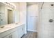 Modern bathroom featuring double sink vanity, white cabinets, large mirror, and tiled shower at 153 Summershore Dr, Auburndale, FL 33823