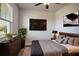 Modern bedroom with a mounted television, bedside lamps, and a large sunny window at 153 Summershore Dr, Auburndale, FL 33823