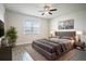 Stylish bedroom with a sleek grey platform bed, wood-look floors, and natural lighting at 153 Summershore Dr, Auburndale, FL 33823