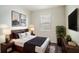 Serene bedroom with a dark wood frame bed, stylish decor, and soft natural light from the window at 153 Summershore Dr, Auburndale, FL 33823