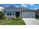 Charming single-story home featuring stone accents, manicured lawn, and a two-car garage at 153 Summershore Dr, Auburndale, FL 33823