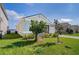 Beautiful home with a gray stucco exterior, well-kept lawn, and a glimpse of the lake in the background at 153 Summershore Dr, Auburndale, FL 33823