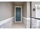 Exterior shot of a home's front door, framed by stone accents and modern lighting at 153 Summershore Dr, Auburndale, FL 33823