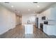 Open-concept kitchen features stainless steel appliances, white cabinets, and a central island at 153 Summershore Dr, Auburndale, FL 33823