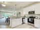 Modern kitchen with white cabinets, stainless steel appliances, granite counters and an open view to dining and living area at 1703 Linz Ct, Winter Haven, FL 33884