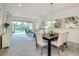 Open-concept living room with dining area, sliding glass doors, and scenic backyard views at 1703 Linz Ct, Winter Haven, FL 33884