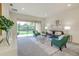 Bright living room featuring neutral tones, stylish furniture, a glass coffee table, and a large sliding glass door at 1703 Linz Ct, Winter Haven, FL 33884