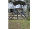 Rustic home featuring a metal awning with an adjacent building, enclosed by a sturdy metal gate at 201 Cleveland Avenue, Winter Haven, FL 33881