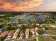 An aerial view of residences bordering a scenic lake system during an orange-hued sunset at 20143 Sunset Landing Ave, Groveland, FL 34736