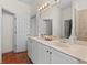 The bathroom has double sinks, a tiled shower, and a large vanity with white cabinets at 20143 Sunset Landing Ave, Groveland, FL 34736
