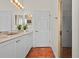 Bright bathroom features a double sink vanity with white cabinets and terracotta tile flooring at 20143 Sunset Landing Ave, Groveland, FL 34736