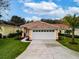 Charming home with a well-manicured lawn, complemented by a two-car garage and tasteful landscaping at 20143 Sunset Landing Ave, Groveland, FL 34736