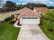 Inviting single-story home featuring a well-manicured lawn and a two-car garage at 20143 Sunset Landing Ave, Groveland, FL 34736