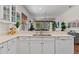 Bright kitchen features white cabinets, updated appliances, and views to the outdoor living space at 20143 Sunset Landing Ave, Groveland, FL 34736