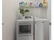 Modern laundry room equipped with a front loading washer and dryer and ample shelving at 20143 Sunset Landing Ave, Groveland, FL 34736