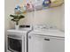 Clean laundry area equipped with a washer, dryer, and an overhead storage shelf at 20143 Sunset Landing Ave, Groveland, FL 34736
