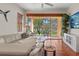 Comfortable living room with terracotta floors, ample natural light, and a view of the backyard at 20143 Sunset Landing Ave, Groveland, FL 34736