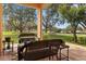 Inviting covered patio with comfortable wicker furniture and scenic views of the landscaped yard at 20143 Sunset Landing Ave, Groveland, FL 34736