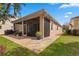 A screened-in porch with a brick-paved patio outside features outdoor furniture and blue potted plants at 20143 Sunset Landing Ave, Groveland, FL 34736