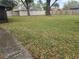 Spacious backyard with a privacy fence and mature trees, offering ample space for outdoor activities at 2016 Amesbury Dr, Auburndale, FL 33823