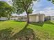 Landscaped backyard featuring a screened-in porch and storage shed at 2434 Mill Run Blvd, Kissimmee, FL 34744