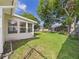 Well-manicured backyard with mature trees and a screened-in porch at 2434 Mill Run Blvd, Kissimmee, FL 34744