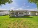 Wide view of a beautiful, grassy backyard with a screened-in porch at 2434 Mill Run Blvd, Kissimmee, FL 34744