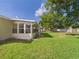 Lush green backyard featuring a screened-in lanai at 2434 Mill Run Blvd, Kissimmee, FL 34744