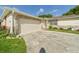 Single-story home featuring a two-car garage and landscaped yard at 2434 Mill Run Blvd, Kissimmee, FL 34744