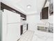 Bright kitchen featuring white appliances, marble-like countertop, and dark brown cabinets at 2434 Mill Run Blvd, Kissimmee, FL 34744