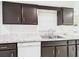 Bright kitchen featuring stainless steel sink, marble-like countertop, and dark brown cabinets at 2434 Mill Run Blvd, Kissimmee, FL 34744
