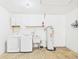 Laundry area in garage features washer, dryer, laundry sink and water heater at 2434 Mill Run Blvd, Kissimmee, FL 34744