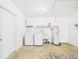 Bright laundry area in the garage includes washer, dryer, utility sink, and storage at 2434 Mill Run Blvd, Kissimmee, FL 34744