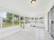 Enclosed sunroom boasting white tiled floor and multiple large windows overlooking the backyard at 2434 Mill Run Blvd, Kissimmee, FL 34744