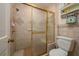 Bathroom with a walk-in shower featuring stone floors, gold trim and a handheld shower at 2506 Partridge Dr, Winter Haven, FL 33884