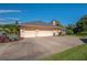 Side view of the house featuring a 3-car garage with a spacious driveway and manicured landscaping at 2506 Partridge Dr, Winter Haven, FL 33884