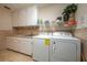 Functional laundry room features a washer, dryer, sink, and ample storage space with white cabinets at 2506 Partridge Dr, Winter Haven, FL 33884