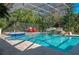 Inviting screened pool with rock waterfall feature, jacuzzi, and lush greenery at 2506 Partridge Dr, Winter Haven, FL 33884