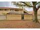 Rear exterior of the home with a covered patio area and mature tree for shade at 26 Casarena Ct, Winter Haven, FL 33881