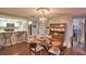 Cozy dining room featuring a modern light fixture, glass-topped table, and adjacent kitchen with bar seating at 26 Casarena Ct, Winter Haven, FL 33881