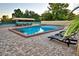 A spacious pool area featuring lounge chairs, shaded seating, and a tennis court in the background at 26 Casarena Ct, Winter Haven, FL 33881