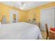 Bright bedroom featuring white bedspread, ceiling fan, and neutral tile floors at 2606 Tall Palm Ave, Lake Wales, FL 33898
