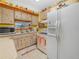 Well-lit kitchen with wood cabinets, white appliances, and a window at 2606 Tall Palm Ave, Lake Wales, FL 33898