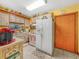 Charming kitchen with wood cabinets, white appliances, and tile floors at 2606 Tall Palm Ave, Lake Wales, FL 33898