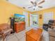 Cozy living room with bright yellow walls, tile flooring, ceiling fan, and comfortable furniture at 2606 Tall Palm Ave, Lake Wales, FL 33898