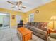 Comfortable living room with a sofa, recliner, tile floors, ceiling fan, and bright yellow walls at 2606 Tall Palm Ave, Lake Wales, FL 33898