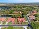Aerial view of a neighborhood boasting lush trees and foliage with a small pond, offering tranquil waterfront views at 2637 Sunburst Ct, Lake Wales, FL 33898