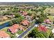 Aerial view of an established neighborhood featuring mature trees, ponds, and single-story homes with red tile roofs at 2637 Sunburst Ct, Lake Wales, FL 33898